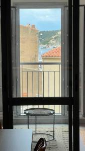 博尼法喬的住宿－D24- T3-Les Hauts du Port-parking-clim-wifi-50m du port，阳台设有桌子和窗户,享有风景。