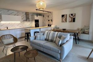 a living room with a couch and a kitchen at D24- T3-Les Hauts du Port-parking-clim-wifi-50m du port in Bonifacio