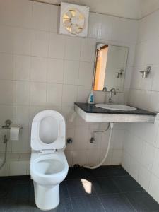 ein Badezimmer mit einem WC, einem Waschbecken und einem Spiegel in der Unterkunft The Loft Kohima 