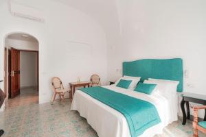 a bedroom with a large bed and a table at Villa Nettuno in Positano