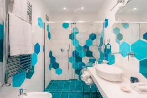 a blue and white bathroom with a shower and a sink at Villa Nettuno in Positano
