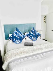 a bed with blue and white pillows on it at Teasa Stays - Upliving Lifestyle nearby Fourways in Northriding