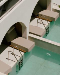 ein Gebäude mit einem Pool mit Bänken im Wasser in der Unterkunft Eterrano Seaside Retreat in Parga