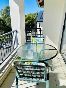 a glass table and a chair on a balcony at Teasa Stays - Upliving Lifestyle nearby Fourways in Northriding