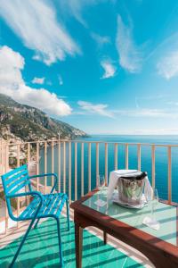 a table and chairs on a balcony with the ocean at Villa Nettuno in Positano
