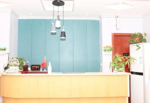 uma cozinha com um balcão e uma parede azul em One Meter Sunshine Xi'an Xianyang International Airport Hotel em Xianyang