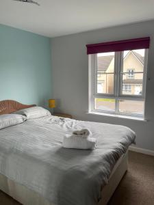 um quarto com uma grande cama branca e uma janela em 3 bed house with parking near airport em Edimburgo