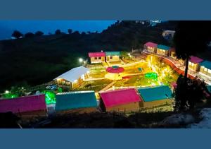 uma vista nocturna para um parque com edifícios coloridos em Bamboo Junction Resort - Kanatal, Valley & Mountain View em Dhanaulti