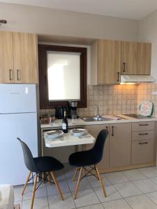 セロカンポスにあるAsteras Apartmentsのキッチン(椅子2脚、テーブル、冷蔵庫付)