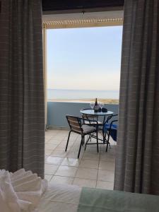 Cette chambre dispose d'une table et offre une vue sur l'océan. dans l'établissement Asteras Apartments, à Xerokampos