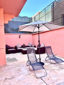 Duas cadeiras e um guarda-sol num pátio em Villa Traditional Family em Marrakech