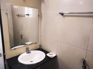 uma casa de banho com um lavatório e um espelho em Hotel Sony Palace, Kolhapur em Kolhapur