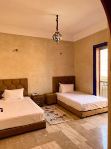 um quarto com 2 camas e um lustre em Villa Traditional Family em Marrakech