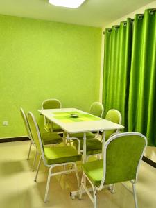 a table and chairs in a room with green curtains at Casa Tranquilla - JKIA in Nairobi