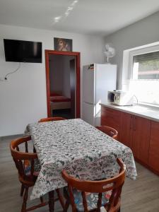 a kitchen with a table with chairs and a refrigerator at Budapest Vendégház in Tiszafüred