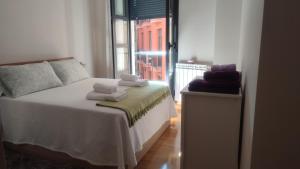 a bedroom with a bed with towels on it at Estudio Paloma in León