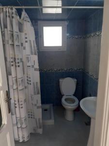 een badkamer met een toilet en een wastafel bij Appartement parfait pour les couples, bien équipé, à Hammamet centre 200m de la plage in Hammamet