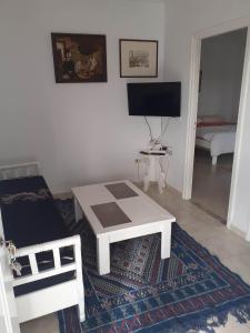 a living room with a coffee table and a television at Appartement parfait pour les couples, bien équipé, à Hammamet centre 200m de la plage in Hammamet