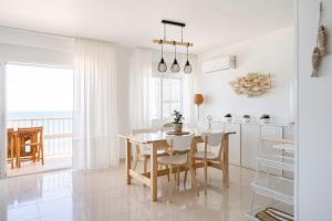 a kitchen and dining room with a table and chairs at El Acuario - Primera línea y todas las ventanas dan al mar in Cullera