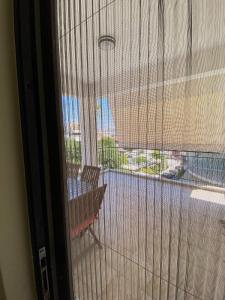 een kamer met een raam met uitzicht op een balkon bij Sunny Apartment Amaliada in Amaliás