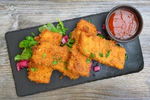 une assiette avec trois morceaux de nourriture frite à la sauce dans l'établissement The Victoria Inn, à Truro