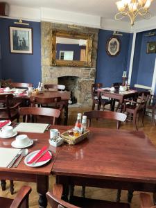 comedor con mesas y sillas y chimenea en No 52 bed and breakfast en Helston