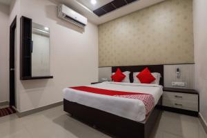 a bedroom with a large bed with red pillows at OYO Ssr Luxury Rooms in Lingampalli