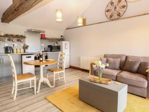 a living room with a couch and a table at Bee Happy Barn in Norwich