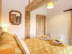 a bedroom with a bed and a mirror on the wall at Bee Happy Barn in Norwich