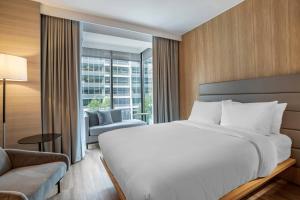 um quarto com uma grande cama branca e uma janela em AC Hotel by Marriott Washington DC Convention Center em Washington