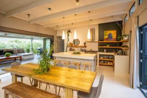 Il comprend une cuisine et un salon avec une table en bois. dans l'établissement Karoo Mountain River House, à Calitzdorp