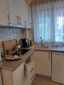 uma cozinha com armários brancos e um prato de comida no balcão em Domenica Studios 2 em Tessalônica