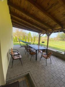 a patio with a table and chairs and a hammock at Nad Doliną Krutyni in Ukta