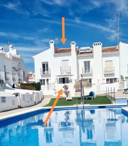 a villa with a swimming pool in front of a building at Casa-Mar Nerja in Nerja