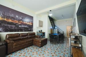 a living room with a leather couch and a table at Spacious&Convenient_3BR/2BT_townhm for group stay in Bangkok