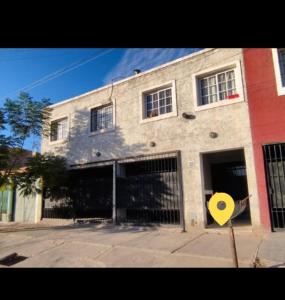 un edificio con una señal amarilla delante de él en Complejo privado guaymallen en Guaymallén
