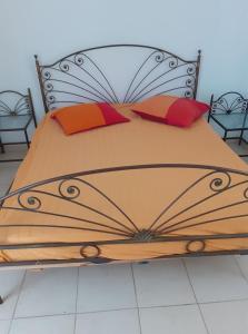 een slaapkamer met een bed met een ijzeren bedframe bij Appartement S2 bien équipé à Hammamet centre (200m de la plage) in Hammamet