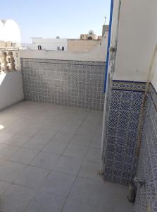 a bathroom with a tiled floor and a wall at Appartement S2 bien équipé à Hammamet centre (200m de la plage) in Hammamet