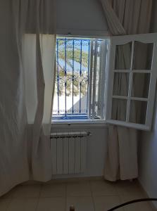 ein Fenster in einem Zimmer mit einem Heizkörper und einem Fenster in der Unterkunft Appartement S2 bien équipé à Hammamet centre (200m de la plage) in Hammamet