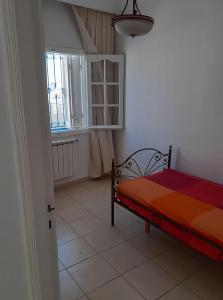 een slaapkamer met een bed en een raam bij Appartement S2 bien équipé à Hammamet centre (200m de la plage) in Hammamet