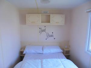 a bedroom with a bed and a sign on the wall at Golden Sands: Mirage IIII:- 6 Berth, Access to the beach in Ingoldmells