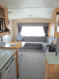 a kitchen and living room with a couch in a caravan at Golden Sands: Mirage IIII:- 6 Berth, Access to the beach in Ingoldmells