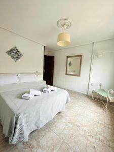 a bedroom with a white bed with towels on it at Apartamento El Arenal - Free Parking in Córdoba