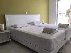 a large white bed with two pillows on it at Kavos Central in Kavos