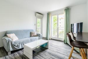 uma sala de estar com um sofá e uma mesa em Appartement tout équipé em Marselha