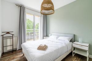 Habitación blanca con cama y ventana en Appartement tout équipé, en Marsella