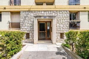 un edificio de piedra con una puerta de madera en la parte delantera en Appartement tout équipé, en Marsella