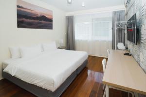 a white bedroom with a bed and a desk at Spacious&Convenient_3BR/2BT_townhm for group stay in Bangkok