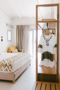 a bedroom with a bed and a dress on a shelf at Eterrano Seaside Retreat in Parga