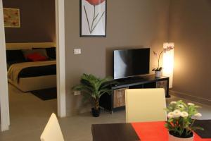 uma sala de estar com televisão e um quarto em Katana Residence em Catânia